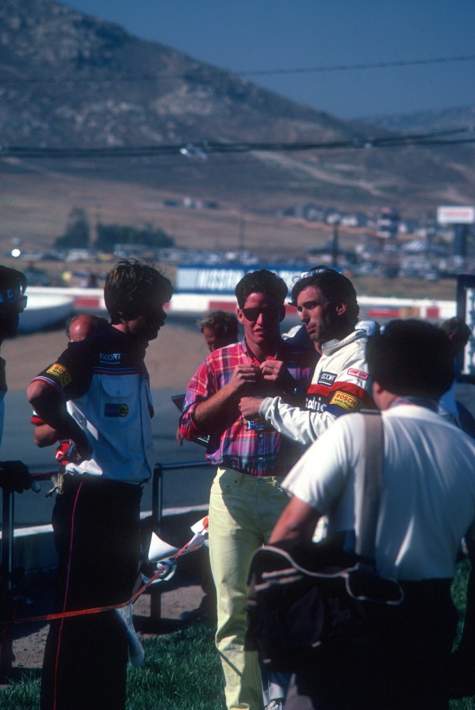 Jim Busby and son and a crew member discussing the teams 1-2 race victory_Riverside Raceway_April 1985 Jim Busby and son and a crew member discussing the teams 1-2 race victory_Riverside Raceway_April 1985