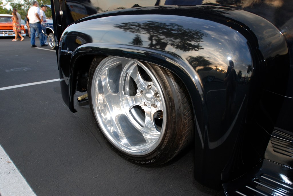 Black  1950's vintage Ford F-100 custom truck_rear fender reflections and wheel detail_Ruby's Diner car show_ Whittier,California_August 3, 2012