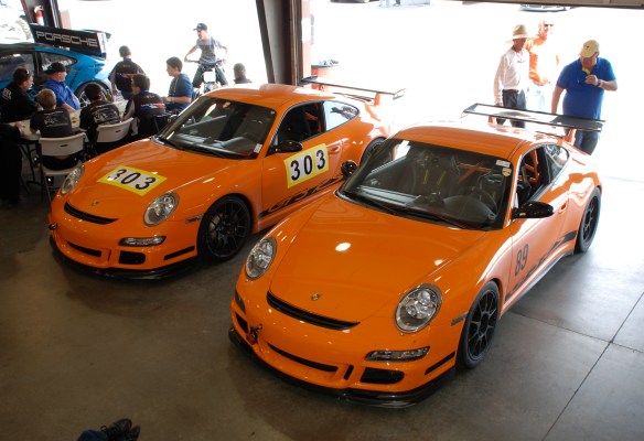 A pair of orange 2007 Porsche GT3RS_#303,#389_ 3/4 front view_Garage 3_California Festival of Speed_April 6, 2013